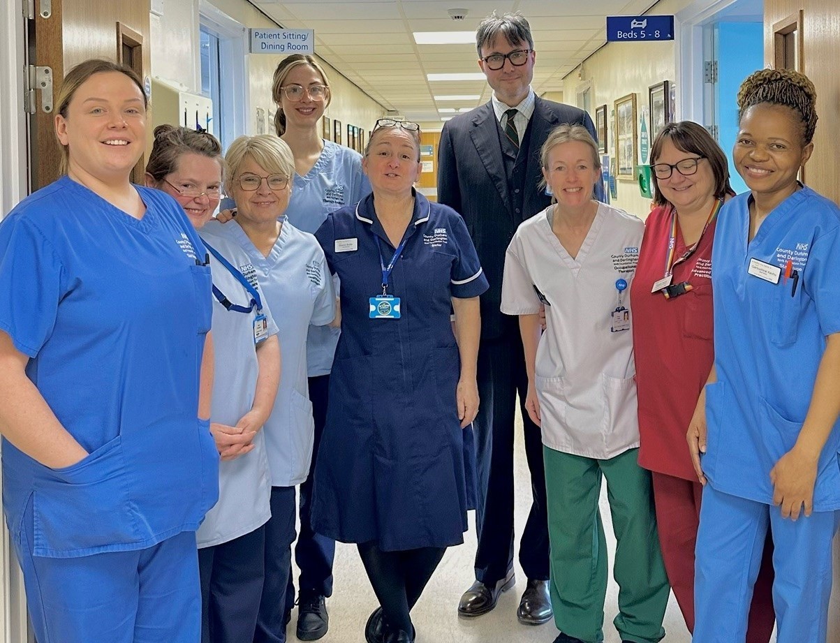 Chairman with hospital staff in uniform smiling